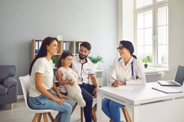 Klinikteki aile doktoru. Anne, baba ve çocuk muayenehanedeki bir çocuk doktoruyla görüşüyor..