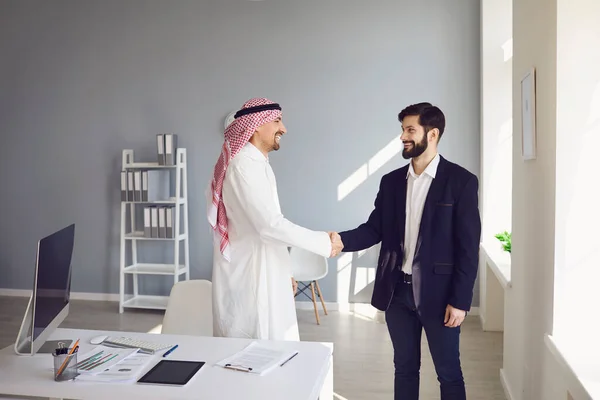 Рукопожатие арабских и европейских бизнесменов в офисе. — стоковое фото