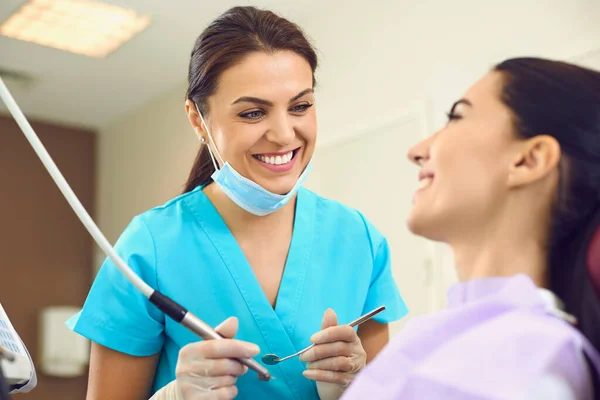 The dentist and the patient are smiling at the dental clinic. — Stock Photo, Image