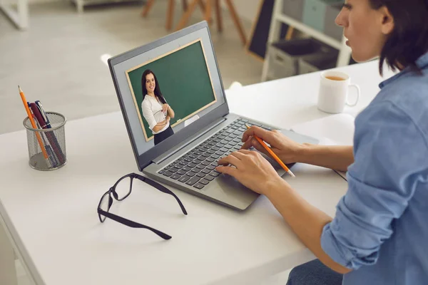 Jovem em casa com laptop usa videochamada e estudos on-line. Ensino à distância na escola, faculdade. Morena professora dando uma palestra na Internet . — Fotografia de Stock