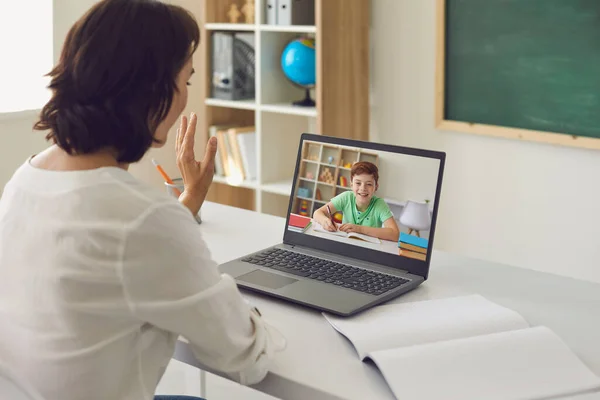 Oktatás oktatás oktatás online. Nő tanár köszönti diák gyermek segítségével laptop online video hívás. — Stock Fotó