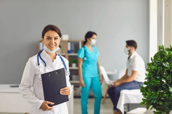 Ärztin blickt bei Patientenbesuch in Kamera — Stockfoto