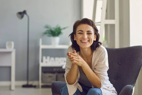 Online communication. Happy young lady smiling at camera while talking to somebody on web from home office — Stock Photo, Image