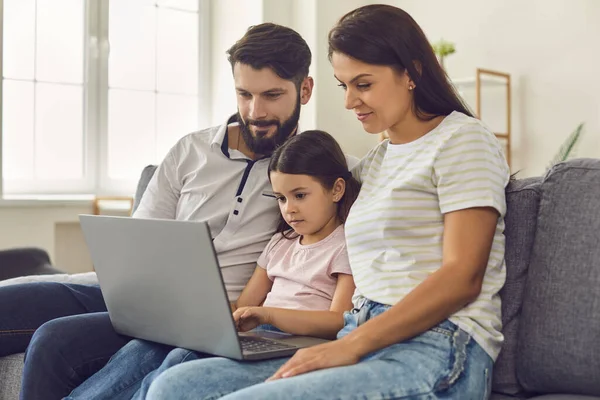 Семья с дочерью ждут видеозвонка для онлайн консультации врача на ноутбуке на дому — стоковое фото