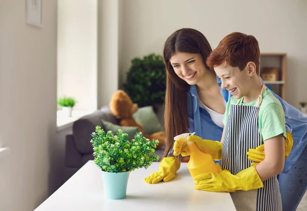 Mother and son having fun while watering houseplant together. — Stock Photo, Image