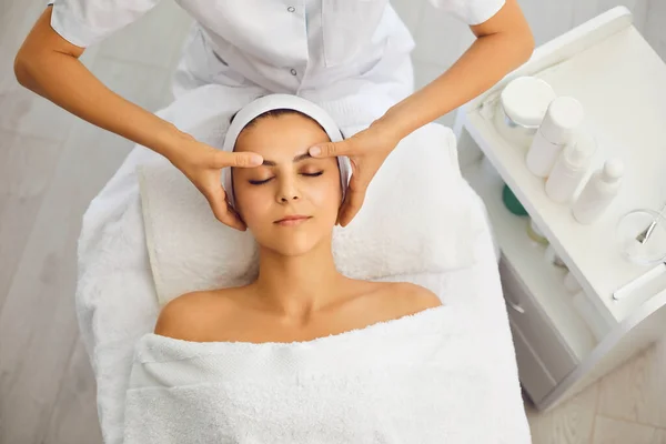 Masaje cara mujer vista superior. Masaje facial en una clínica de belleza. —  Fotos de Stock