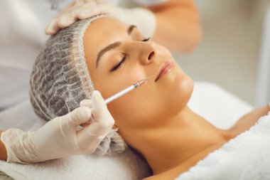 Dudaklarda güzellik aşıları. Kozmetoloji ve profesyonel cilt bakımı. Güzellik salonundaki kadın. Plastik Cerrahi Kliniği.