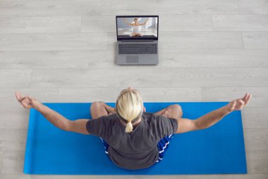 Yoga meditasyonu devrede. Sarışın adam evde yoga yapıyor. Beyaz saçlı bir adam gri bir odada otururken meditasyon yapıyor..