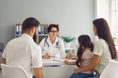 Aile doktoru klinikteki hastalara gülümsüyor..