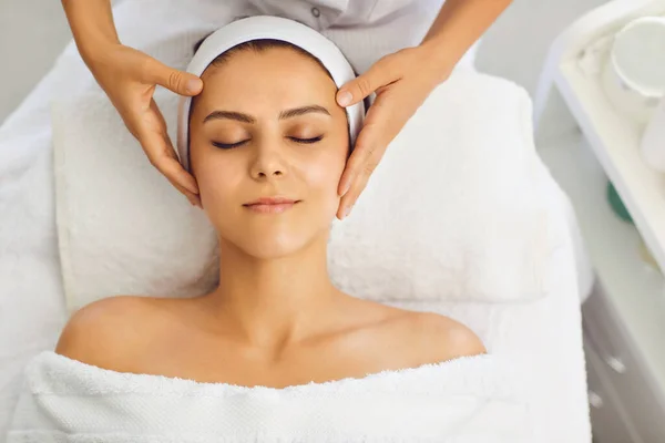 Жіночий масаж обличчя в салоні краси. Косметолог робить лікування шкіри обличчя в клініці краси — стокове фото