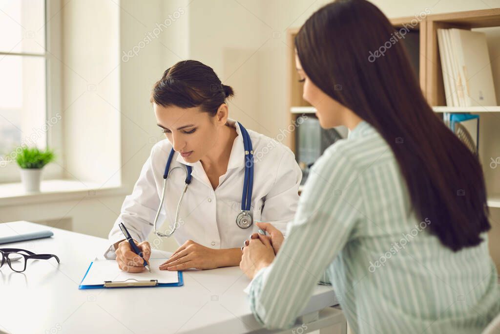 Healthcare and medicine. Young woman on visit to doctor at hospital. Female patient consulting with physician at clinic