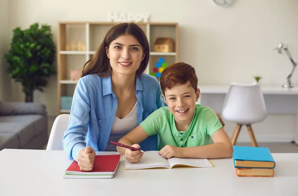 Educação online. Mãe e filho felizes olhando para a câmera durante o webinar com o professor. Criança e pai estudando em casa — Fotografia de Stock