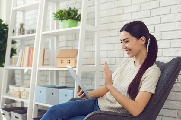 Glückliches junges Mädchen, das von zu Hause aus auf dem Tablet-Computer online kommuniziert. Geschäftsfrau nimmt an Webkonferenz teil — Stockfoto