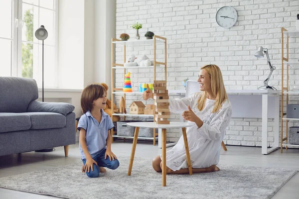 Madre e hijo se divierten jugando juegos de mesa en casa. —  Fotos de Stock