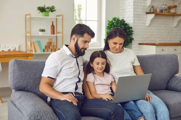 Familia portátil en línea. Familia feliz utiliza videollamada portátil mientras está sentado en el sofá en casa. — Foto de Stock
