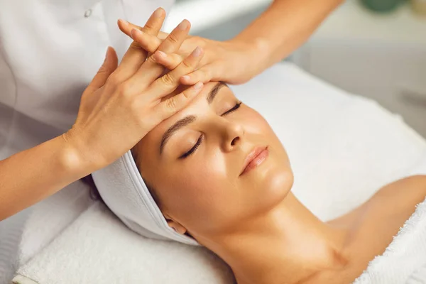 Cosmetologue faire un massage facial ou un traitement pour les jeunes femmes visage dans le salon de beauté spa — Photo