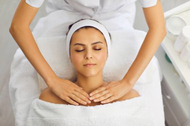 Kozmetik uzmanı ya da masör güzellik salonundaki kadın için omuz kemeri masajı yapıyor.