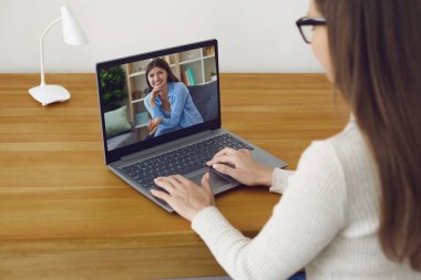Kız video kamerayla bir dizüstü bilgisayarla iletişim kuruyor. Eğitim, online çalışma. Evde çalış, serbest çalışan. Çevrimiçi kurslar