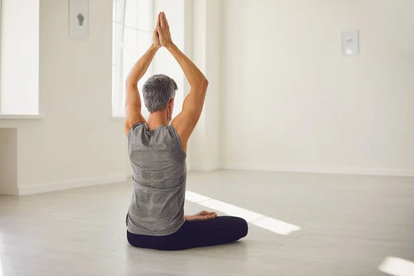 Yogamannen. Skäggig kille utövar yoga i en lotusposition sittande i en studio — Stockfoto