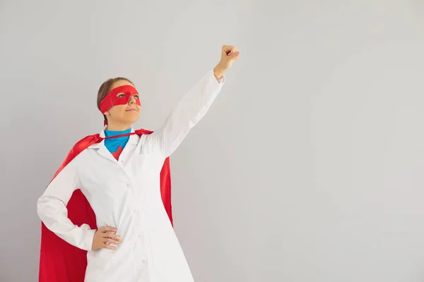 Médico jovem em traje de super-herói pronto para combater doenças, fundo cinza. Trabalhador médico contra infecções — Fotografia de Stock