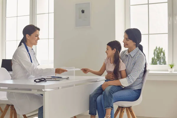 Médecin donnant une prescription médicale à la mère et à la petite fille à la clinique — Photo