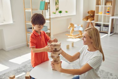 Mutlu anne güler yüzlü oğlu evde ahşap parça piramidi inşa etmek için