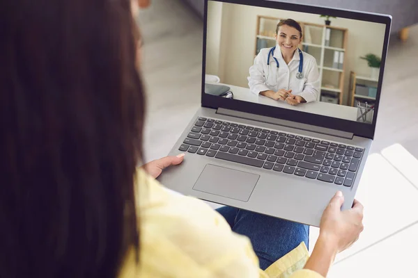 Online doctor consultation. Woman is at home, uses online doctor service.