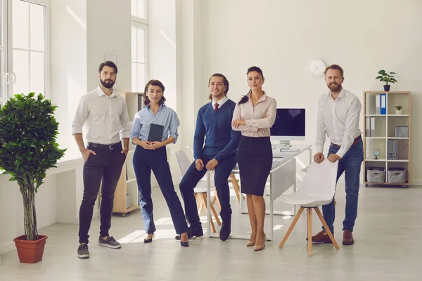 Groupe de jeunes professionnels debout dans un bureau moderne prêt pour une réunion d'entreprise — Photo