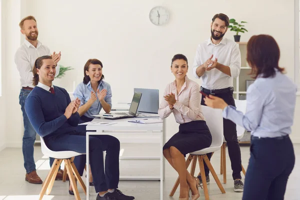 Skupina usměvavých podnikatelů, kteří sedí v kanceláři a diskutují o novém projektu nebo spolu — Stock fotografie