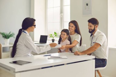 Klinikteki doktorun muayenesinde mutlu bir aile..