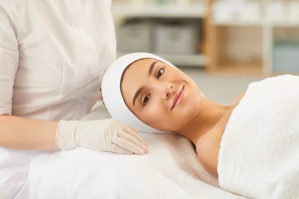 Souriant jeune femme regardant la caméra après la procédure de massage facial — Photo