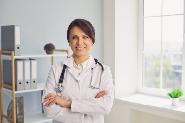 Kadın doktor hastanedeki kameraya bakıyor. İnternet üzerinden müşteriyle iletişim kuran, internet üzerinden danışmanlık yapan bir tıp çalışanı.