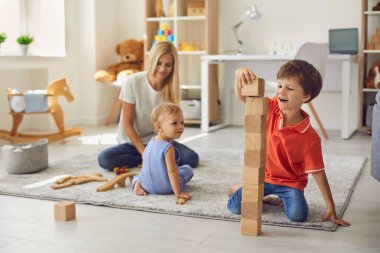 Annem evde yerde mutlu çocuklarla oynuyor.