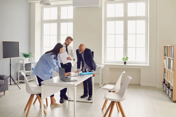 Team of office employees analyzing data reports or dealing with software problems