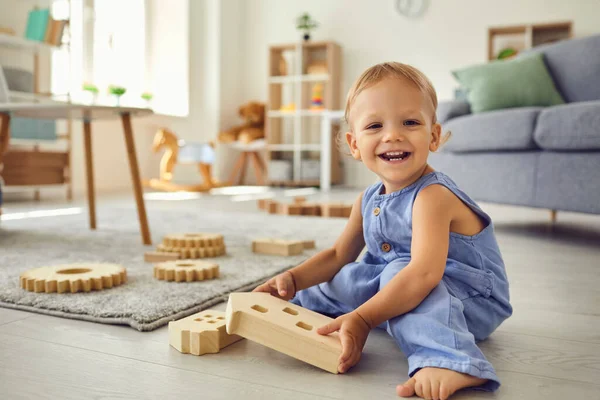 Petit enfant mignon regardant la caméra souriant joyeusement tout en jouant dans la chambre de pépinière confortable — Photo