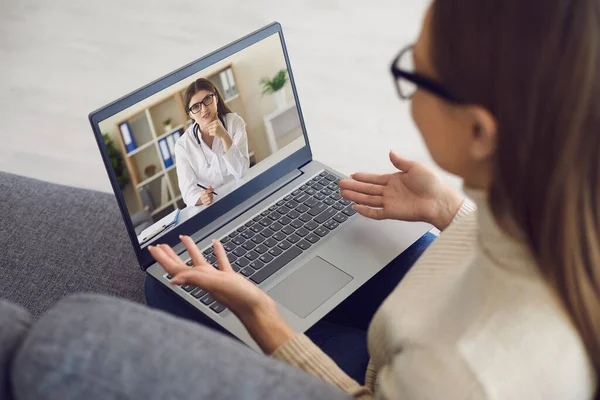 Doktor a vonalban. Női beteg mondja terapeuta használ laptop webkamera otthon. Az orvos távolról konzultál a lánnyal.. — Stock Fotó