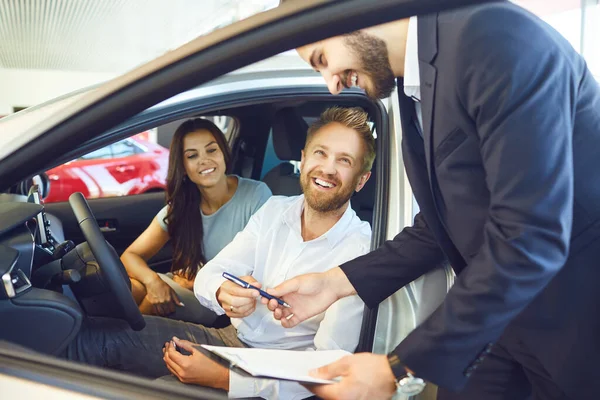 Um casal compra um carro em um showroom de carro. — Fotografia de Stock