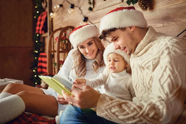 Glückliche Familie liest zu Weihnachten ein Buch. — Stockfoto