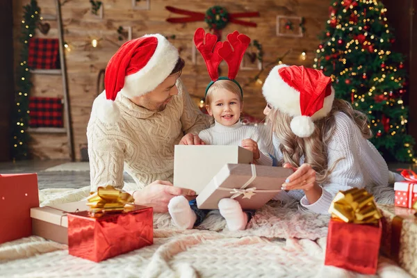 La familia da regalos al niño en la habitación en Navidad — Foto de Stock