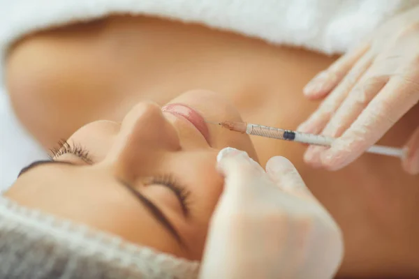 Cosmetologist fazendo botox enchimento injeção em lábios femininos com seringa no salão de beleza — Fotografia de Stock