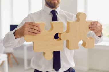 Kırpılmış işadamı ya da şirket yöneticisi yapbozun iki parçasını birleştiriyor.
