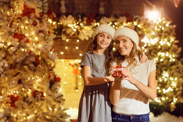 Daughter gives a gift in a room at Christmas. — Stock Photo, Image