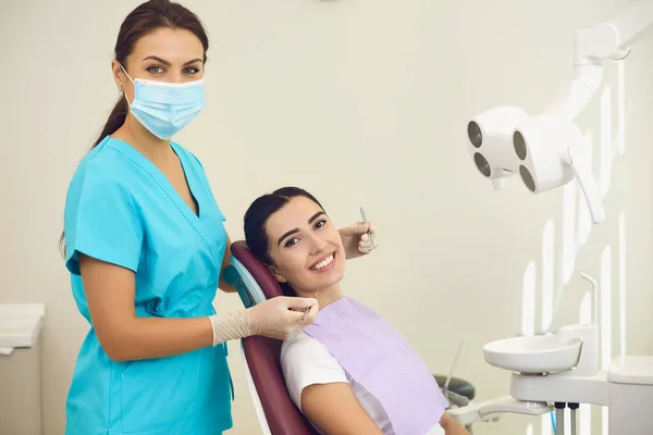 Portrait of a friendly smiling female dentist with a patient in the office of a dental clinic. — Stock Photo, Image
