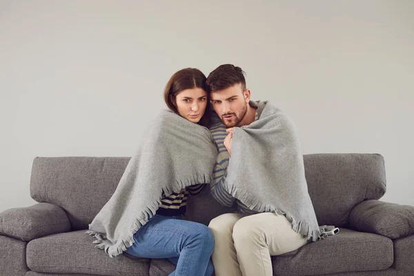 Freezing couple in cool room cuddling in plaid — Stock Photo, Image