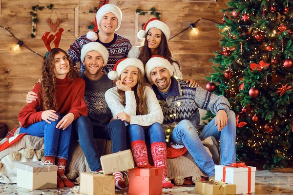 Amigos alegres con regalos que celebran la Navidad — Foto de Stock