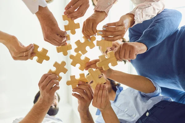 Положительные работники компании играют с головоломкой во время работы в команде — стоковое фото