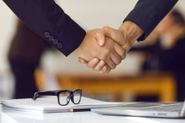 Close-up of business partners shaking hands making deal and confirming collaboration