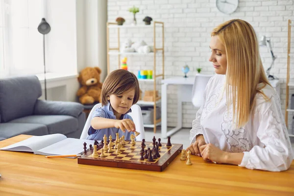 Ibu dan anak bermain catur di meja di home.Happy keluarga dengan orang tua dan anak menikmati papan permainan di rumah — Stok Foto