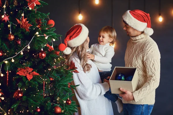 La famille décore le sapin de Noël dans la chambre à Noël — Photo