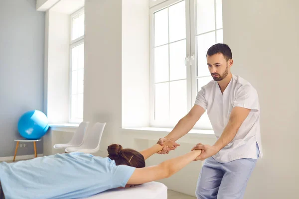 Quiropráctico masculino o terapeuta manual que cura el problema de la columna vertebral de los clientes en el centro de salud moderno —  Fotos de Stock